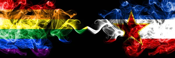 Bandeiras de fumaça gay vs Iugoslávia colocadas lado a lado. Bandeiras de fumo sedoso de cor grossa do Orgulho e da Iugoslávia — Fotografia de Stock