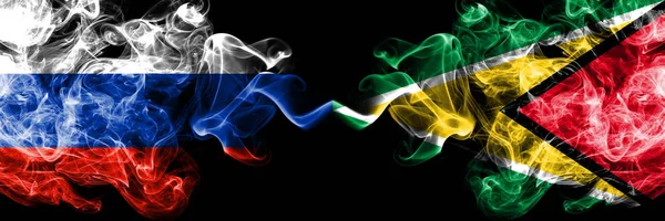 Drapeaux de fumée russes vs Guyane, Guyanais placés côte à côte. Drapeaux de fumée soyeux de couleur épaisse de la Russie et du Guyana, Guyanais — Photo