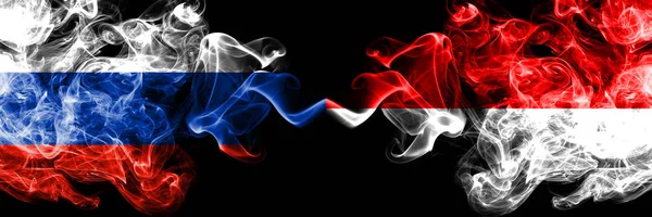 Россия против Индонезии, индонезийские дымовые флаги стоят бок о бок. Толстые цветные шелковистые дымовые флаги России и Индонезии, Индонезии — стоковое фото