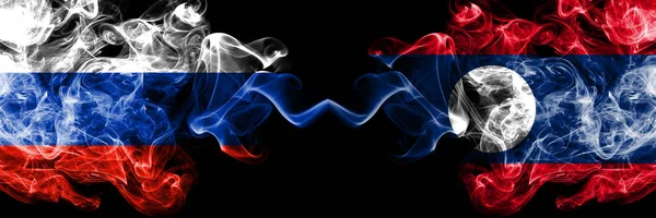 Banderas de humo rusas vs Laos colocadas una al lado de la otra. Banderas de humo sedoso de color grueso de Rusia y Laos — Foto de Stock