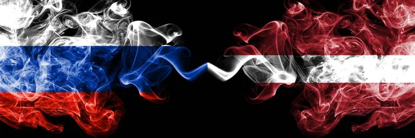 Rusia vs Letonia, banderas de humo letonas colocadas una al lado de la otra. Banderas de humo sedoso de color grueso de Rusia y Letonia, Letonia — Foto de Stock