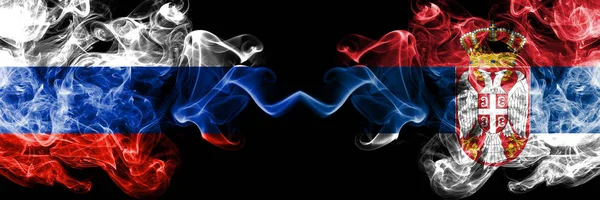 Ryska vs Serbien, serbiska rökflaggor placerade sida vid sida. Tjock färgad silkeslen rök flaggor av Ryssland och Serbien, serbiska — Stockfoto