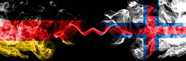 Almanya vs Faroe Adaları dumanlı mistik bayraklar yan yana yerleştirilir. Deutschland ve Faroe Adaları kalın renkli ipeksi duman bayrakları