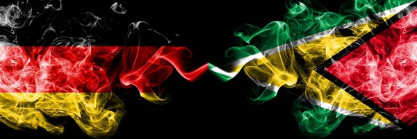 Germany vs Guyana, Guyanese smoky mystic flags placed side by side. Thick colored silky smoke flags of Deutschland and Guyana, Guyanese — Stock Photo, Image
