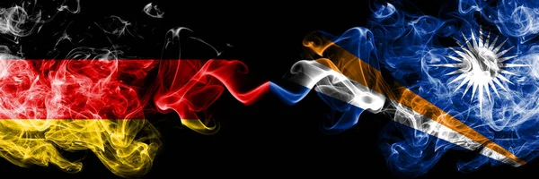Niemcy vs Wyspy Marshalla smoky Mystic flagi umieszczone obok siebie. Grube, jedwabiste flagi dymu z Niemiec i Wysp Marshalla — Zdjęcie stockowe
