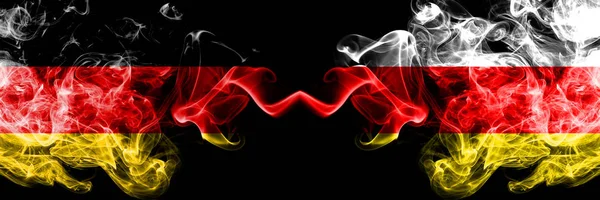 Deutschland gegen Südossetien rauchen mystische Fahnen nebeneinander. dicke seidige Rauchfahnen von Deutschland und Südossetien — Stockfoto