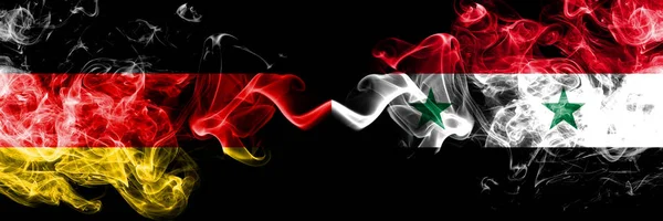 Tyskland vs Syrien, syriska rökig Mystic flaggor placerade sida vid sida. Tjocka färgade silkeslen rök flaggor av Deutschland och Syrien, syriska — Stockfoto