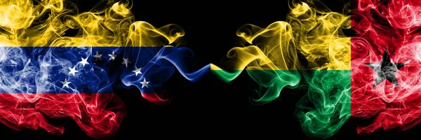 व्हेनेझुएला वि गिनी बिसाऊ धूम्रपान करणारे रहस्यमय झेंडे बाजूला ठेवले. व्हेनेझुएला आणि गिनी बिसाऊचे जाड रंगीत रेशीम धूर झेंडे — स्टॉक फोटो, इमेज