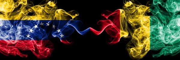Βενεζουέλα εναντίον Γουινέας, Guinean smoky mystic σημαίες τοποθετούνται δίπλα-δίπλα. Χοντρές χρωματιστές μεταξένιες σημαίες καπνού της Βενεζουέλας και της Γουινέας, Γουινέα — Φωτογραφία Αρχείου