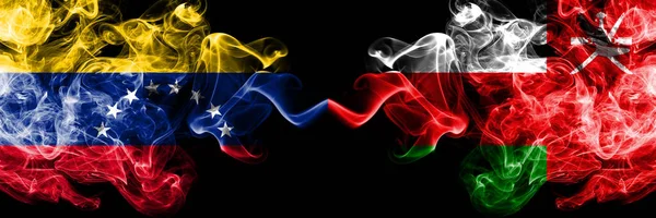 Venezuela vs Oman, Omani rokerige mystieke vlaggen naast elkaar geplaatst. Dikke gekleurde zijdeachtige rook vlaggen van Venezuela en Oman, Omani — Stockfoto