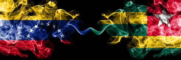Venezuela vs Togo, tožské kouřové mystické vlajky umístěné bok po boku. Silné barevné hedvábné dýmové vlajky Venezuely a Toga v Tožském — Stock fotografie