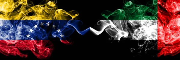 Венесуела проти Об'єднаних Арабських Еміратів, Еміраті, курять містичні прапори, поміщені пліч-о-пліч. Товсті кольорові прапори диму Венесуели та Об'єднаних Арабських Еміратів, Еміраті — стокове фото