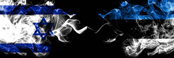 Israel vs Estônia, bandeiras místicas fumegantes estonianas colocadas lado a lado. Bandeira de fumaça sedosa de cor grossa de Israel e Estônia, estoniano — Fotografia de Stock