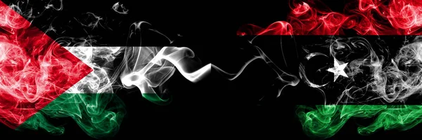 Palesztina vs Líbia, Líbia füstös misztikus zászlók elhelyezett egymás mellett. Vastag színes selymes füst zászlaja palesztinok és Líbia, Líbiai — Stock Fotó