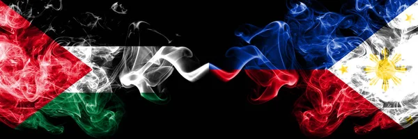 Палестина против Филиппин, филиппинские дымящиеся мистические флаги, размещенные бок о бок. Толстые цветные шелковистые курит флаг палестинцев и Филиппин, филиппинцев — стоковое фото