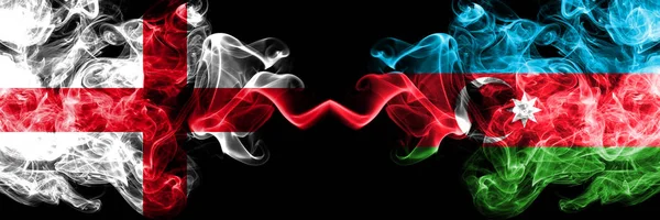 Engelska vs Azerbajdzjan, azerbajdzjanska rökiga mystiska flaggor placerade sida vid sida. Tjocka färgade silkeslena röker flagga av England och Azerbajdzjan, azerbajdzjanska. — Stockfoto