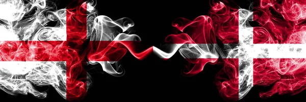 Engelska vs Danmark, danska rökiga mystiska flaggor placerade sida vid sida. Tjocka färgade silkeslena röker flagga av England och Danmark, danska. — Stockfoto