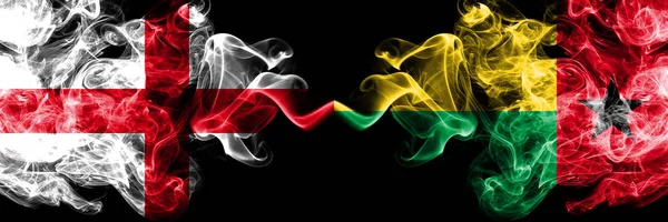 English vs Guinea Bissau smoky mystic flags placed side by side. Thick colored silky smokes flag of England and Guinea Bissau. — Stock Photo, Image