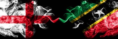 İngilizce vs Saint Kitts ve Nevis dumanlı mistik bayraklar yan yana yerleştirilir. Kalın renkli ipeksi İngiltere ve Saint Kitts ve Nevis bayrağı dumanlar.