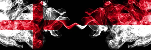 Inglês vs Mônaco, Monacan bandeiras místicas fumegantes colocados lado a lado. Bandeira de fumaça sedosa de cor grossa da Inglaterra e Mônaco, Monacan . — Fotografia de Stock