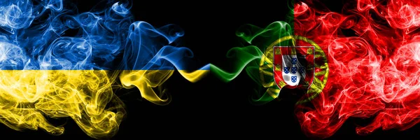 Украина и Португалия соревнуются толстыми красочными дымчатыми флагами. Квалификация европейских футбольных команд — стоковое фото