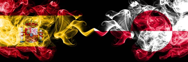 Ισπανία vs Γροιλανδία καπνιστή μυστικιστικές σημαίες τοποθετημένα δίπλα-δίπλα. Παχιά χρώμα μεταξένια καπνίζει σημαία της Ισπανίας και της Γροιλανδίας — Φωτογραφία Αρχείου