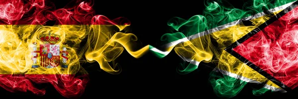 España vs Guyana, banderas místicas ahumadas guyanesas colocadas una al lado de la otra. Bandera de humo sedoso de color grueso de España y Guyana, Guyana — Foto de Stock