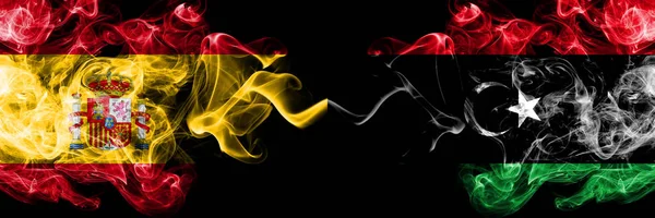 España vs Libia, banderas místicas de humo libio colocadas una al lado de la otra. Bandera de humo sedoso de color grueso de España y Libia, Libia — Foto de Stock