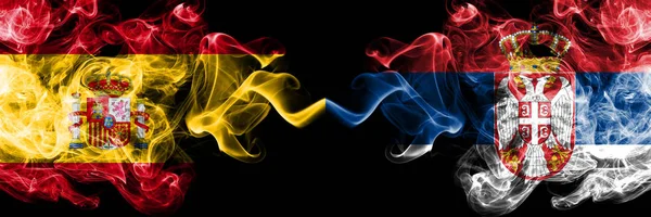 España vs Serbia, banderas místicas ahumadas serbias colocadas lado a lado. Bandera de humo sedoso de color grueso de España y Serbia, Serbia — Foto de Stock