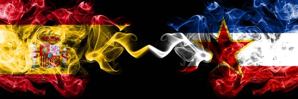 Ισπανία vs Γιουγκοσλαβία καπνίζουν μυστικιστικές σημαίες τοποθετημένες δίπλα-δίπλα. Παχιά χρωματισμένη μεταξένια σημαία της Ισπανίας και της Γιουγκοσλαβίας — Φωτογραφία Αρχείου