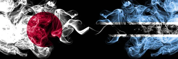 Japan vs Botswana, Botswanan rökiga mystiska flaggor placerade sida vid sida. Tjocka färgade silkeslena röker kombination av Botswana, Botswanan och japanska flaggan — Stockfoto