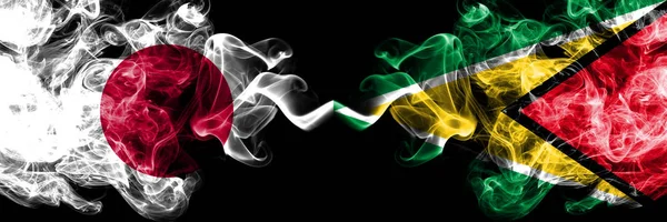 Japan VS Guyana, Guyanese rokerige Mystic vlaggen geplaatst naast elkaar. Dikke gekleurde zijdeachtige rookt combinatie van Guyana, Guyanese en Japanse vlag — Stockfoto