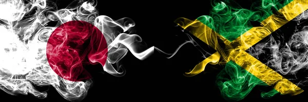 Giappone vs Giamaica, bandiere mistiche affumicate giamaicane affiancate. Spessa combinazione di sigarette colorate di seta di Giamaica, Giamaica e bandiera giapponese — Foto Stock