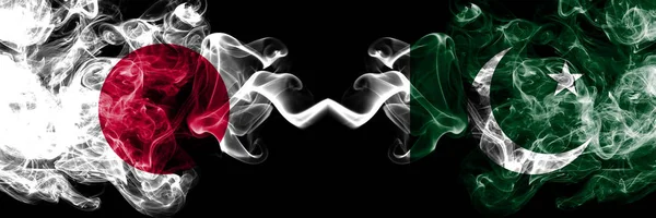 Japón vs Pakistán, banderas místicas pakistaníes colocadas una al lado de la otra. Gruesa combinación de humo sedoso de Pakistán, Pakistán y la bandera japonesa — Foto de Stock