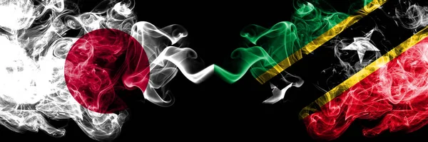 Japonia vs Saint Kitts i Nevis smoky mistyczne flagi umieszczone obok siebie. Grube kolorowe jedwabiste pali połączenie Saint Kitts i Nevis i japońskiej flagi — Zdjęcie stockowe