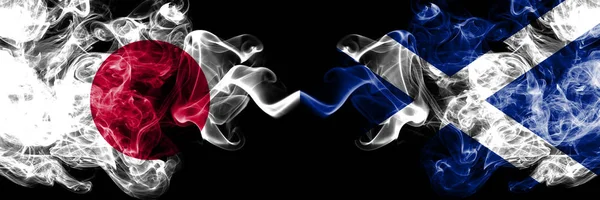 Япония против Шотландии, шотландские дымящиеся мистические флаги, помещенные бок о бок. Толстые цветные шелковистые сигареты сочетание Шотландии, Шотландии и Японии флага — стоковое фото