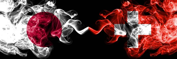 Japan vs Schweiz, schweiziska rökig Mystic flaggor placerade sida vid sida. Tjocka färgade silkeslena röker kombination av Schweiz, schweiziska och japanska flaggan — Stockfoto