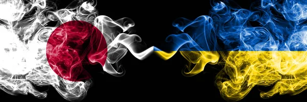 日本对乌克兰,乌克兰烟熏神秘旗帜并排放置。浓重的彩色丝烟组合乌克兰,乌克兰和日本国旗 — 图库照片