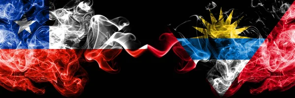 Chile vs Antigua and Barbuda smoky mystic flags placed side by side. Thick colored silky smokes combination of Antigua and Barbuda and Chilean flag