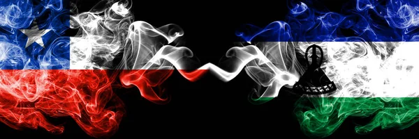Drapeaux mystiques fumés Chili vs Lesotho placés côte à côte. Combinaison épaisse de fumées soyeuses du Lesotho et du drapeau chilien — Photo