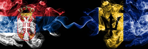 Σερβία vs Μπαρμπάντος, Μπαρμπάντος καπνίζουν μυστικιστικές σημαίες τοποθετημένες δίπλα-δίπλα. Πυκνός έγχρωμος μεταξένια καπνίζει συνδυασμός σερβικών και Μπαρμπάντος, σημαία Μπαρμπάντος — Φωτογραφία Αρχείου