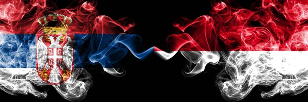 塞尔维亚 vs 摩纳哥， 莫纳坎烟熏神秘旗帜并排放置.厚厚的彩色丝烟组合塞尔维亚和摩纳哥，莫纳坎国旗 — 图库照片