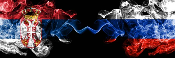 Serbien vs Ryssland, ryska rökiga mystiska flaggor placerade sida vid sida. Tjocka färgade silkeslena röker kombination av serbiska och Ryssland, ryska flaggan — Stockfoto