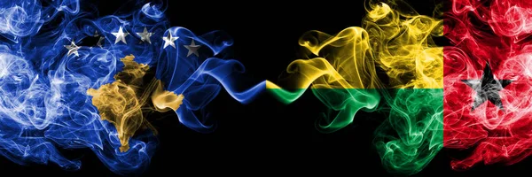 Drapeaux mystiques fumés Kosovo vs Guinée Bissau placés côte à côte. Combinaison de fumées soyeuses de couleur épaisse du drapeau du Kosovo et de la Guinée Bissau — Photo