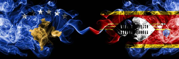 Косово против Свазиленда, Свазиленда, курящие мистические флаги, размещенные бок о бок. Толстый шелковистый дым сочетание Косово и Свазиленда, флаг Свази — стоковое фото
