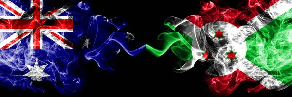 Austrália vs Burundi, bandeiras místicas esfumaçadas do Burundi colocadas lado a lado. Combinação de fumaça sedosa de cor grossa de bandeiras nacionais da Austrália e Burundi, Burundi — Fotografia de Stock