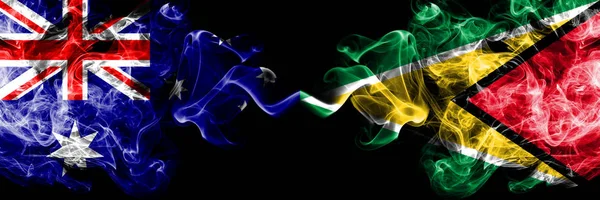 Australia vs Guyana, Guyanese smoky mystic flags placed side by side. Thick colored silky smokes combination of national flags of Australia and Guyana, Guyanese — Stock Photo, Image