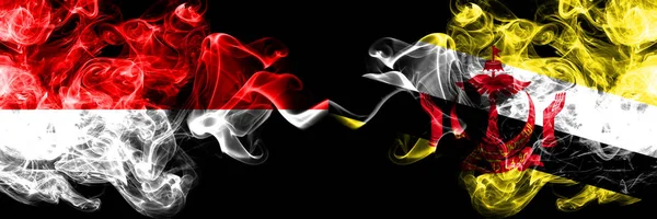 インドネシア vs ブルネイ, ブルネイスモーキー神秘的なフラグが並んで配置.インドネシアとブルネイ、ブルネイの濃い色の絹のような煙の旗 — ストック写真