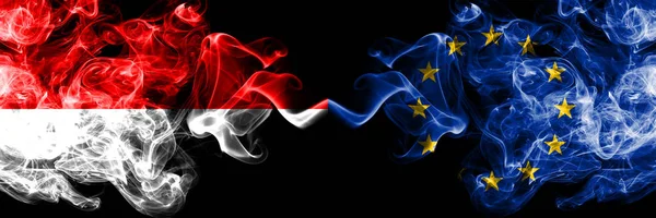 Indonesia vs Unión Europea, banderas místicas humeantes de la UE colocadas lado a lado. Banderas de humo sedoso de color grueso de Indonesia y la Unión Europea, UE — Foto de Stock