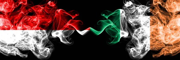 Індонезія проти Ірландії, ірландський димчастий містичних прапори розміщені пліч-на-пліч. Товсті кольорові і шовковисте дим прапори Індонезії та Ірландії, ірландський — стокове фото